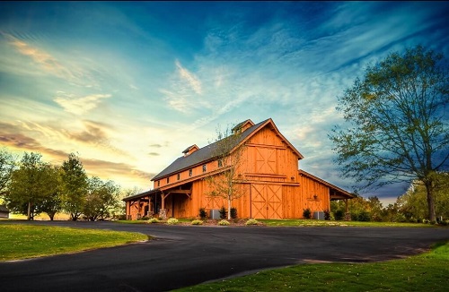 Windy Hill Wedding and Event Barn in front of beautiful sunlit sky with wispy clouds