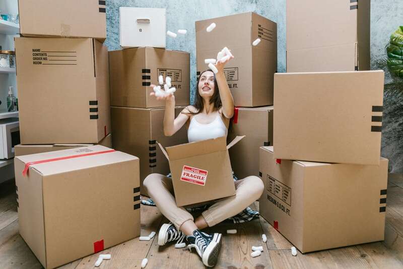 woman sitting on floor among moving boxes