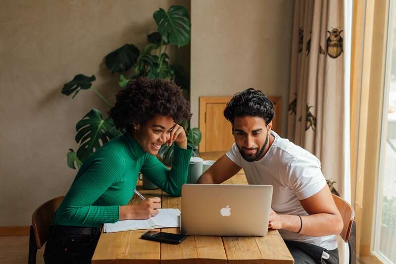 Woman and a Man Looking at the Screen of a Laptop