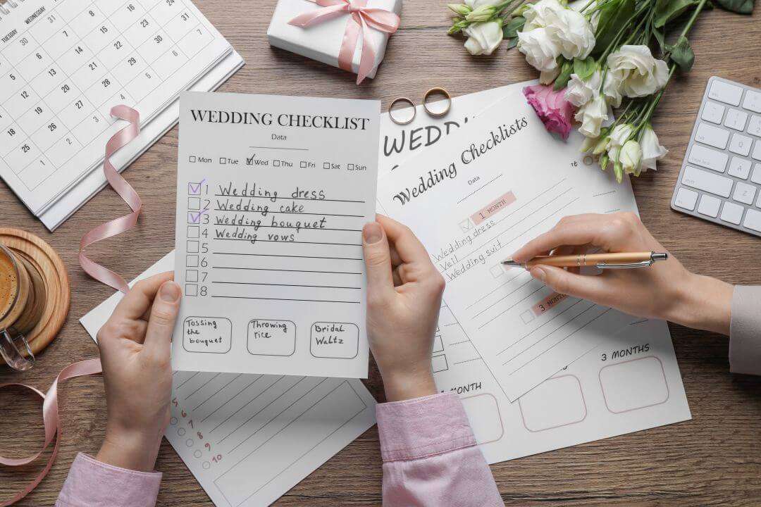 Women-filling-Wedding-Checklists-at-wooden-table-top-view-